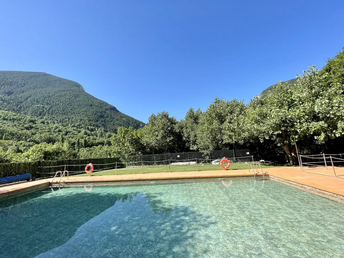 Piscina del camping con la montaña al fondo